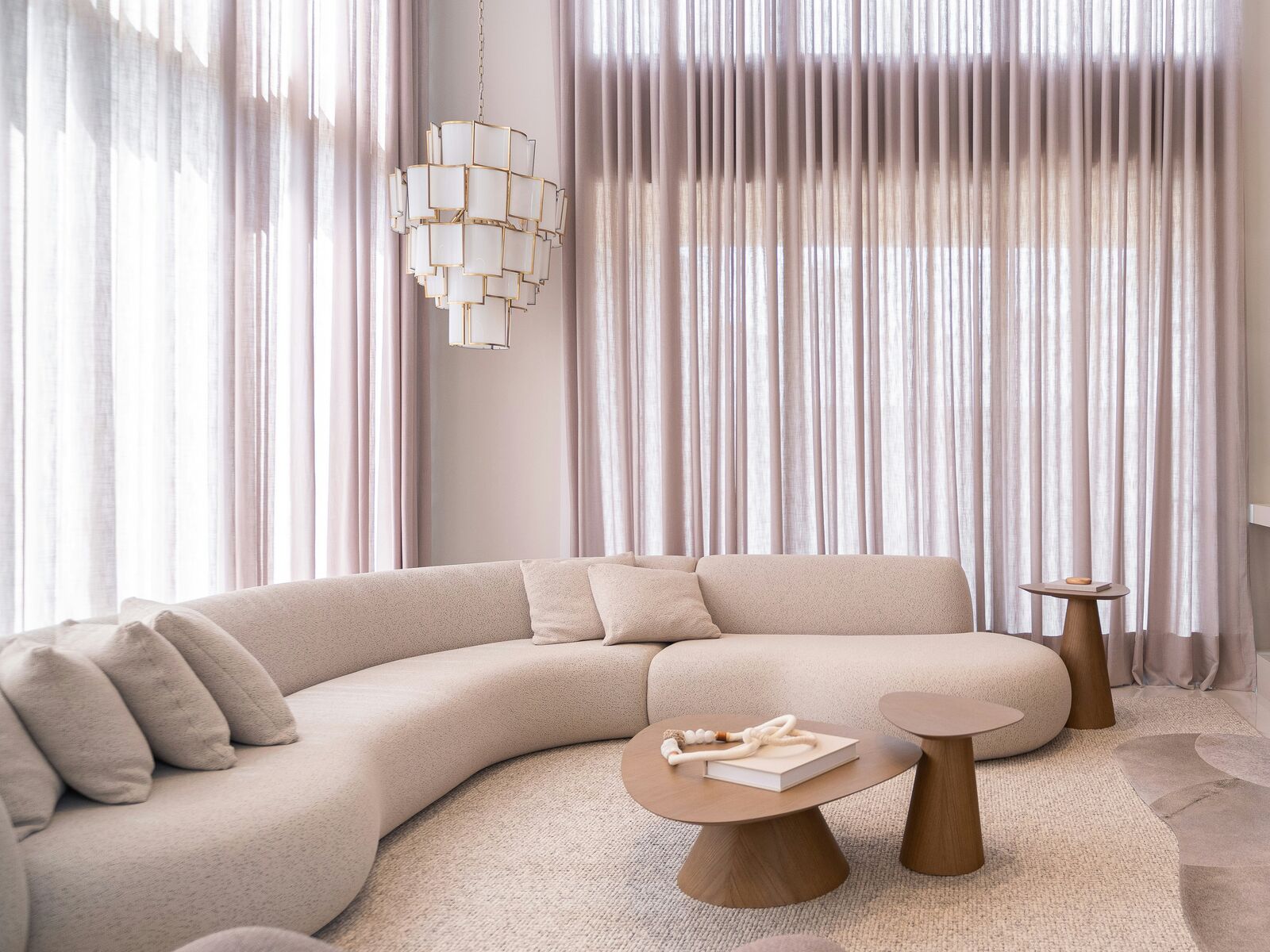 Salón con cortinas translúcidas de doble altura